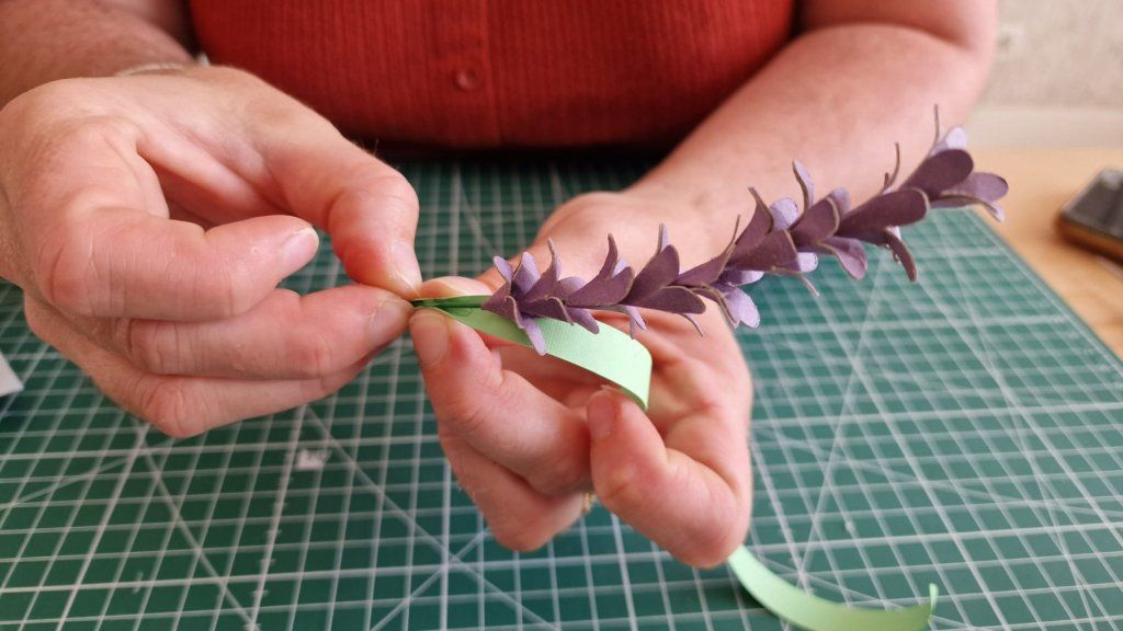 7) Fixer les feuilles vertes à la base de la dernière petite fleur.