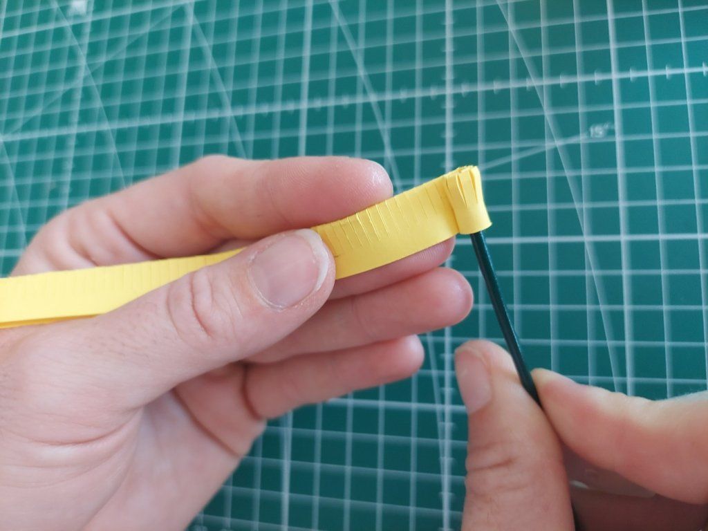 3° : Enrouler la bande jaune sur elle-même. Coller au fur et à mesure.