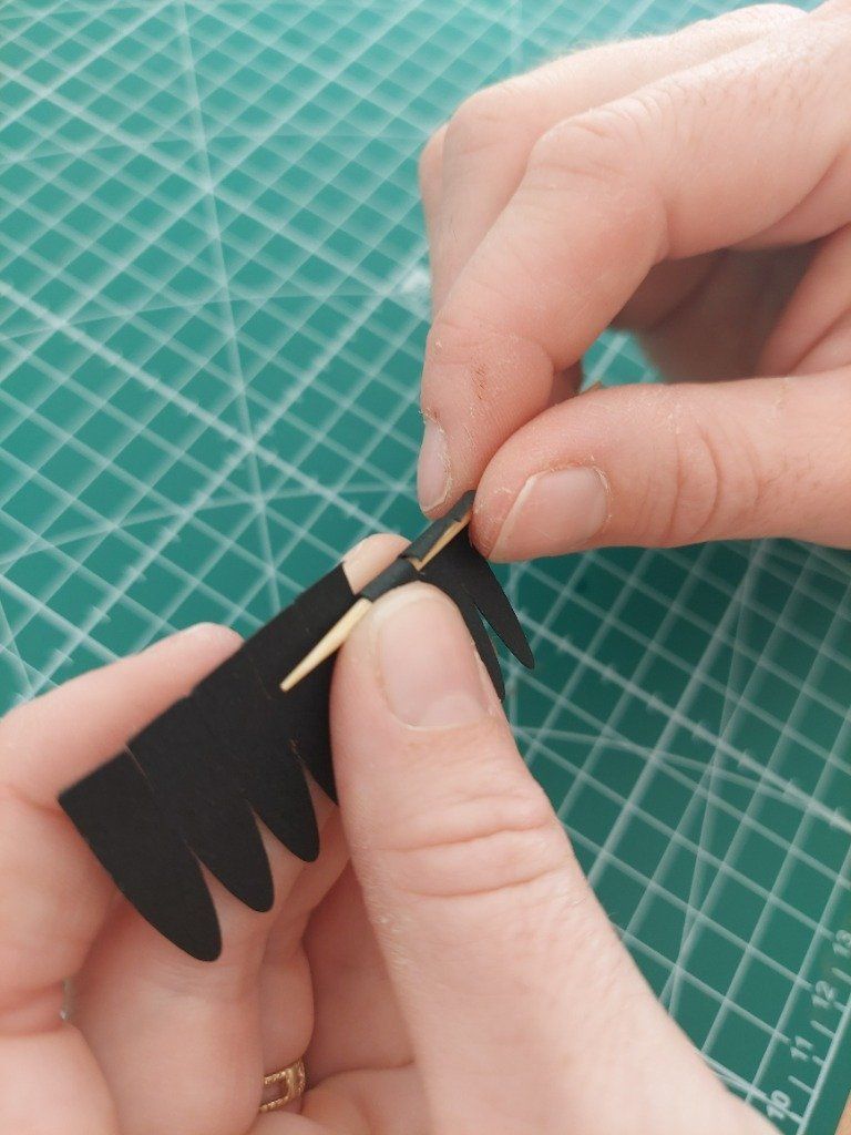 1)- Enrouler la base de la petite bande de papier noir à l'aide d'un cure dent.