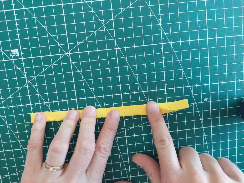 1° : Plier la bande jaune en deux ans le sens de la longueur.