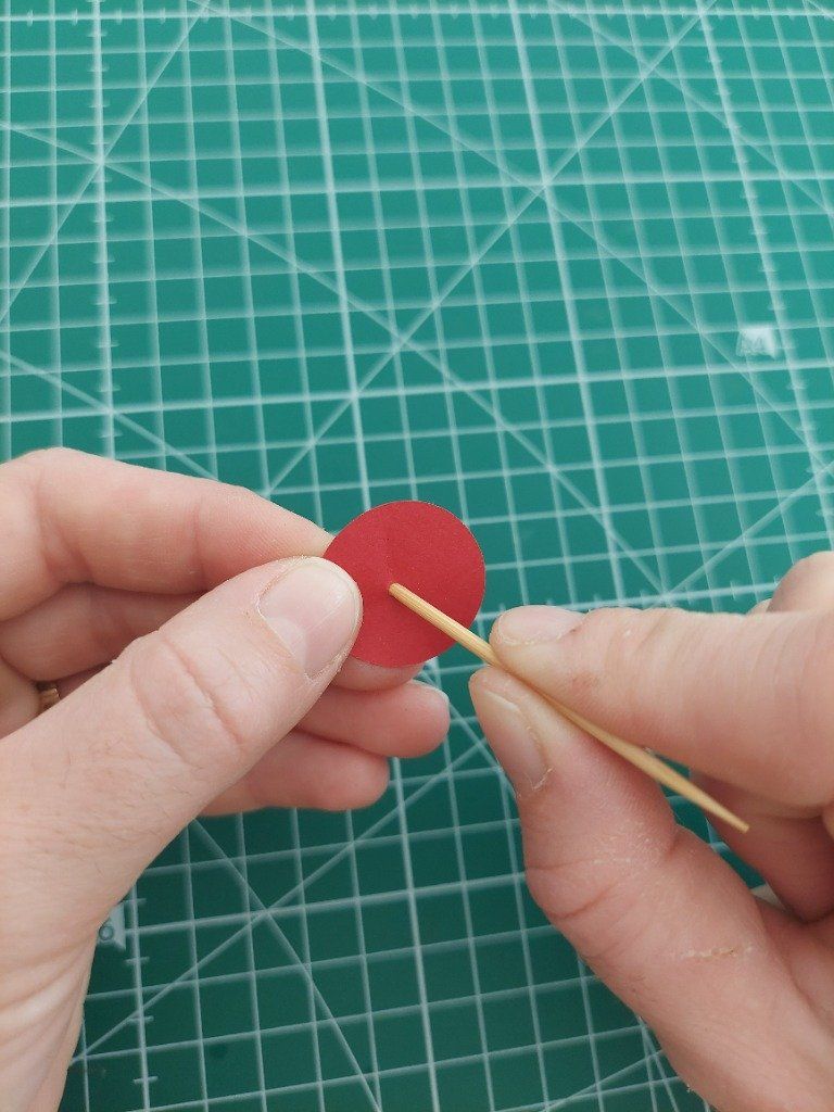 8)- A l'aide d'un cure-dent, percer un trou au centre du cercle de papier rouge.