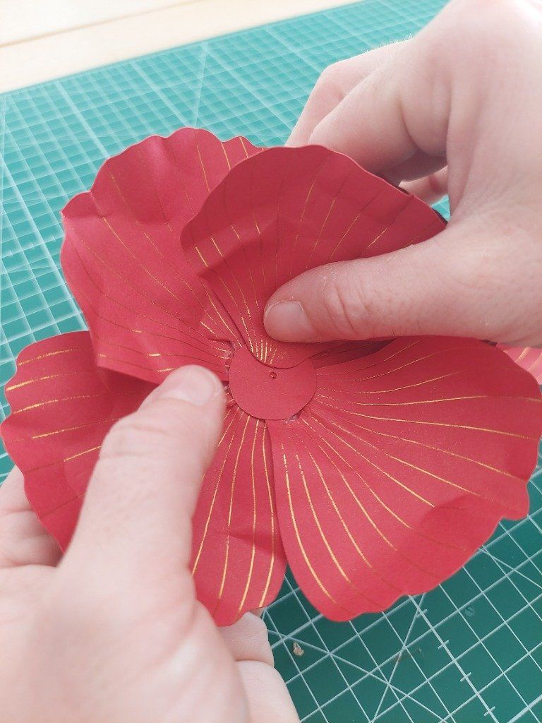 10)- Coller, à la colle chaude, les petites pétales sur les cercles de papier rouge.